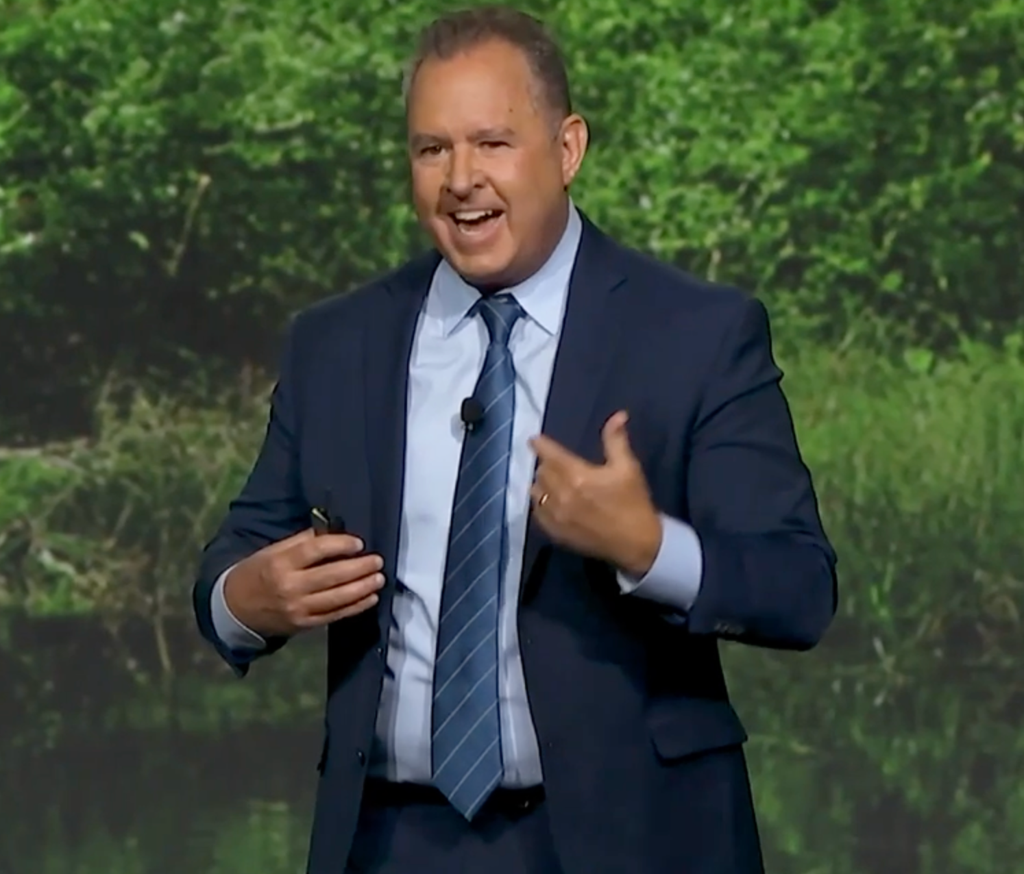Jeff smiling and gesturing while presenting on stage